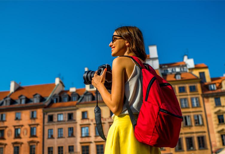 Young woman with camera on the Warsaw Old Town