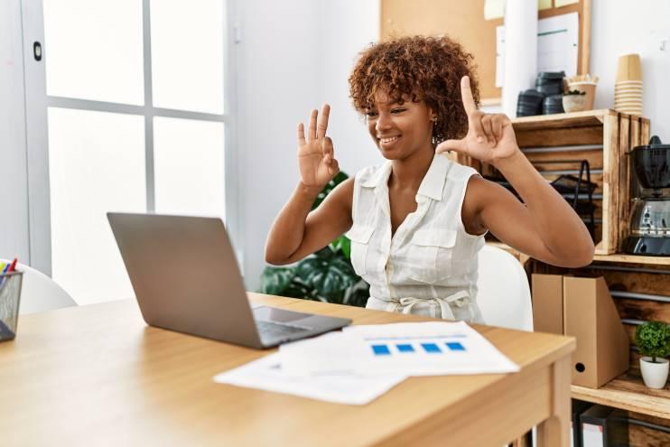 Black deaf woman signing in front of computer