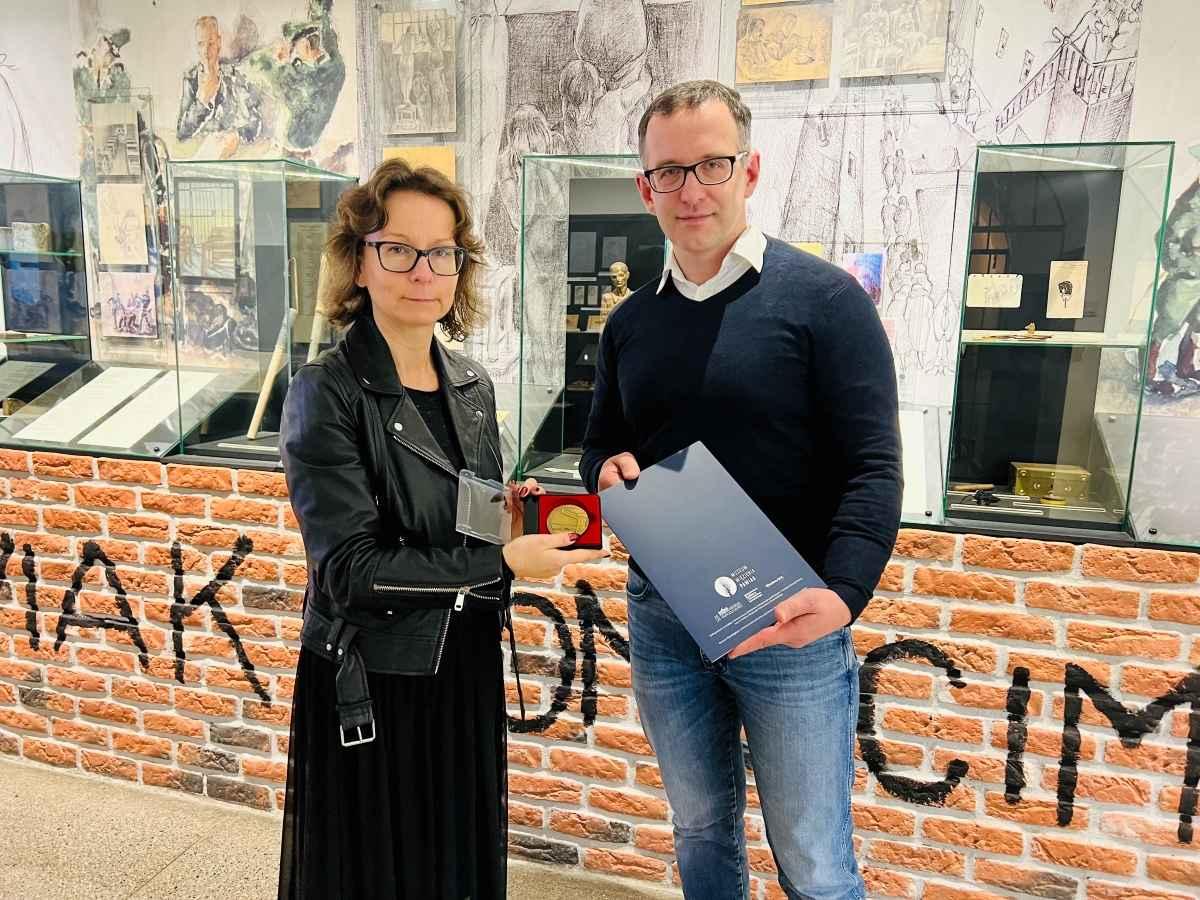 Adam Szpaderski accepting the Pawiak Prison Museum medal