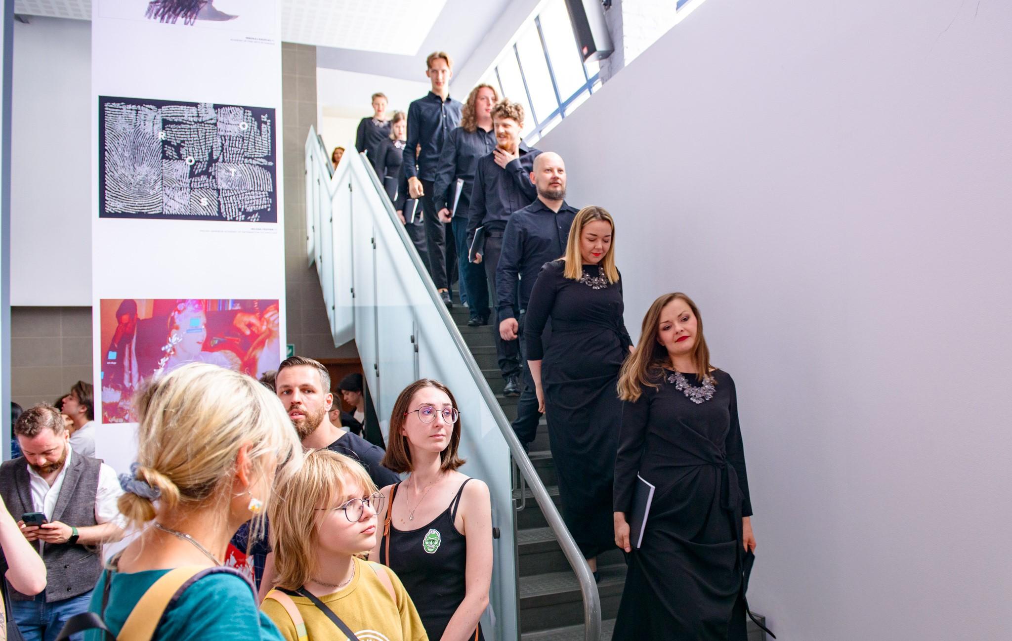 Members of the choir going down the stairs to start their performance