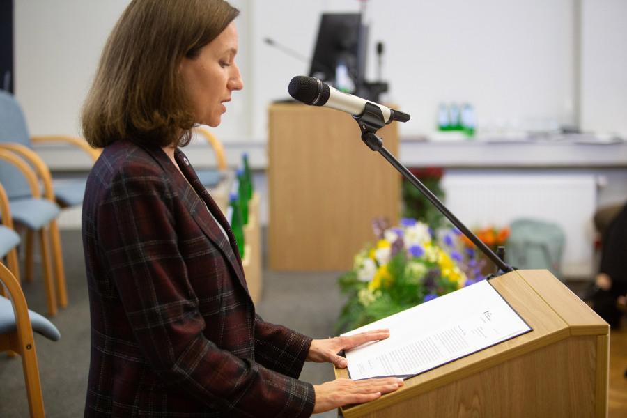 Prof. Aleksandra Cisłak-Wójcik giving a speech at a podium.