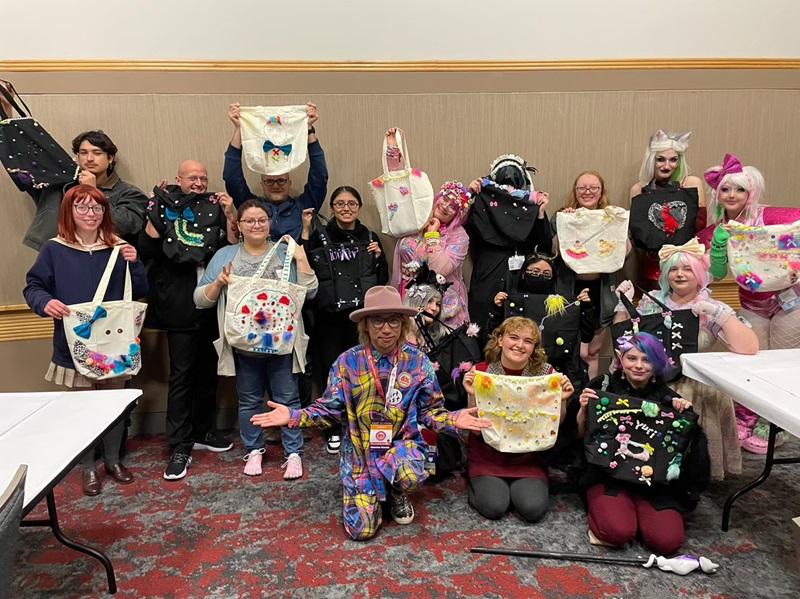 Sebastian Masuda with group of workshop participants, showing their hand made tote bags