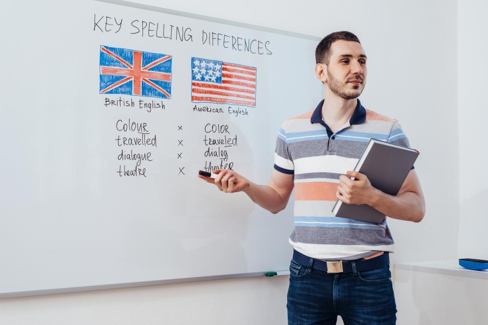 Male teacher of English pointing to a blackboard