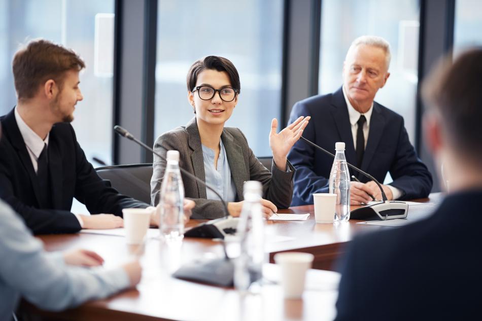 Young woman speaks at a board meeting